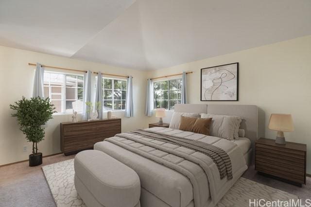 bedroom with vaulted ceiling and light colored carpet