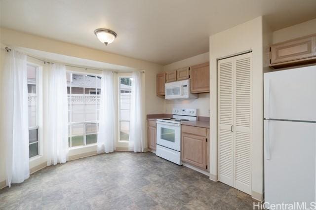 kitchen with light brown cabinets and white appliances