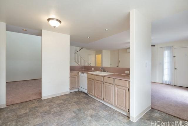 kitchen with light brown cabinetry, sink, light carpet, white dishwasher, and kitchen peninsula