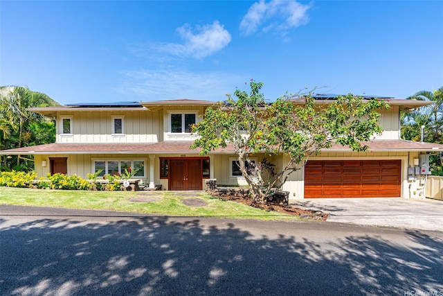 view of front of house with roof mounted solar panels, concrete driveway, and a garage