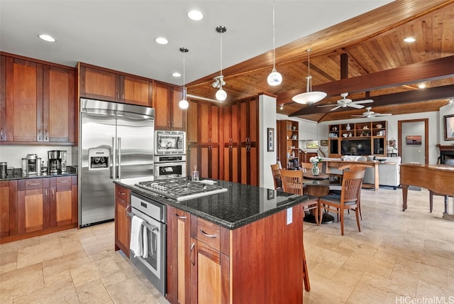 kitchen featuring built in appliances, decorative light fixtures, a kitchen island, beamed ceiling, and dark stone counters