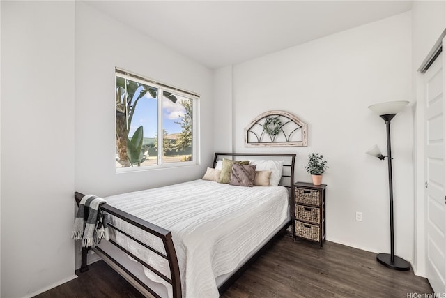 bedroom featuring baseboards and dark wood-style floors