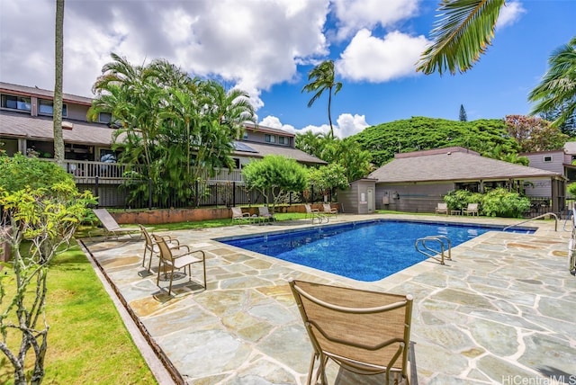 pool featuring a patio and fence