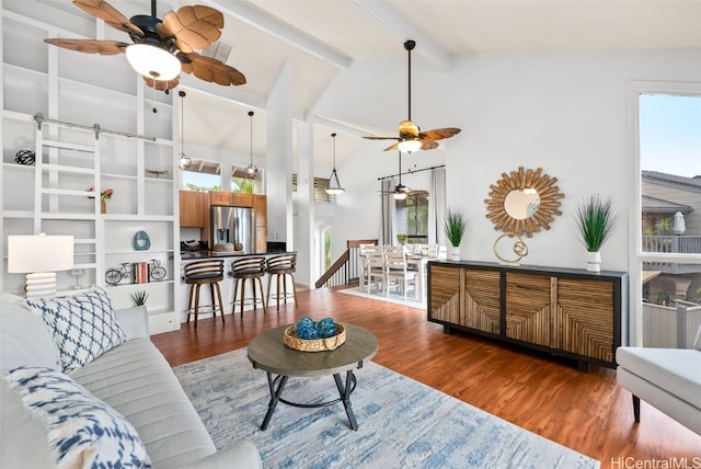 living room with beamed ceiling, high vaulted ceiling, and wood finished floors