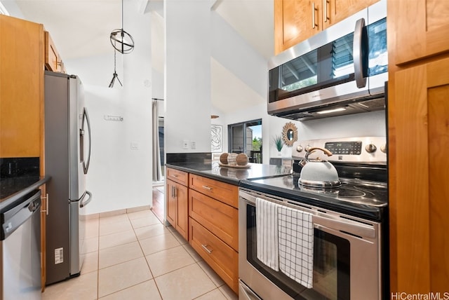 kitchen with high vaulted ceiling, light tile patterned flooring, stainless steel appliances, dark countertops, and brown cabinets