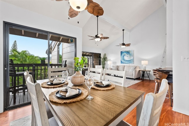 dining space with high vaulted ceiling and wood finished floors