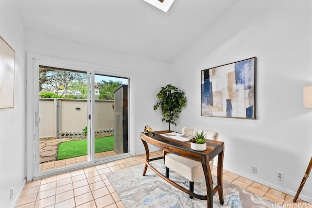 tiled office featuring vaulted ceiling with skylight and baseboards