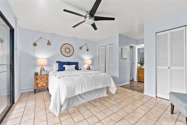 bedroom featuring baseboards, multiple closets, light tile patterned flooring, and a ceiling fan