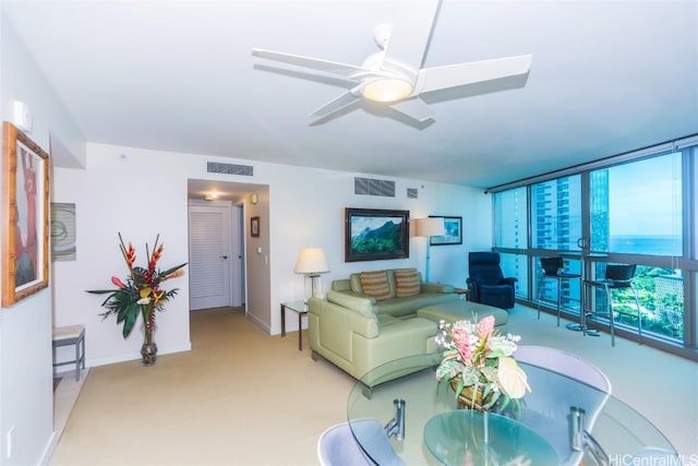 living room featuring a wall of windows, light colored carpet, and ceiling fan