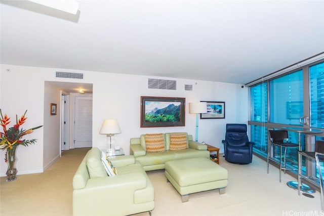 carpeted living room featuring floor to ceiling windows