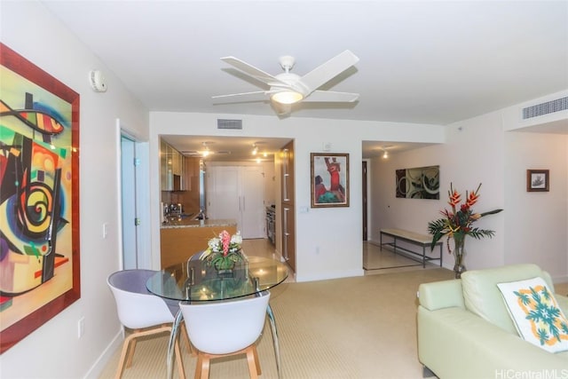 carpeted dining room with ceiling fan