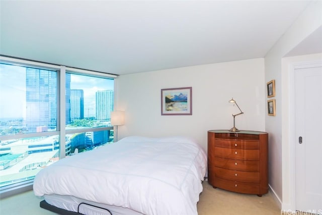 bedroom with a wall of windows and light carpet