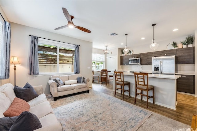 living room featuring ceiling fan and light wood-type flooring