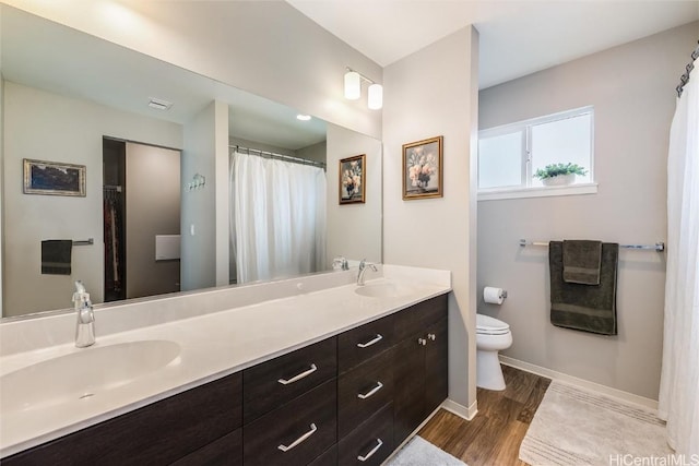 bathroom with hardwood / wood-style flooring, vanity, and toilet