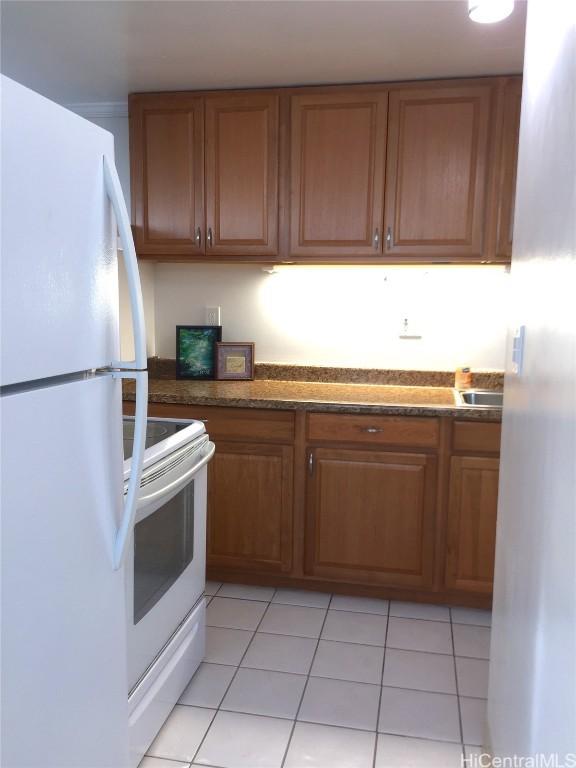 kitchen featuring light tile patterned flooring and white appliances