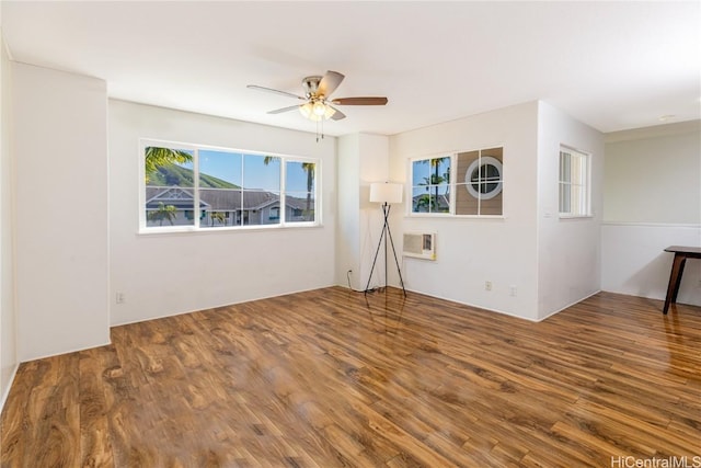 unfurnished room featuring wood-type flooring, an AC wall unit, and ceiling fan