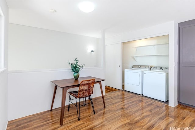 laundry room featuring separate washer and dryer and light hardwood / wood-style flooring