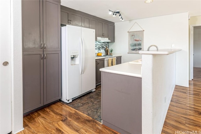 kitchen with dark hardwood / wood-style flooring, tasteful backsplash, white fridge with ice dispenser, and gray cabinets