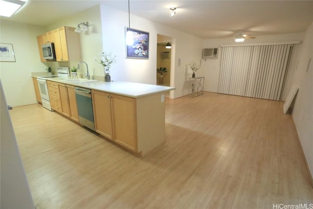 kitchen featuring sink, appliances with stainless steel finishes, light hardwood / wood-style floors, decorative light fixtures, and light brown cabinets