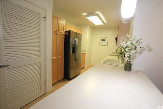 kitchen with stainless steel refrigerator with ice dispenser, light brown cabinetry, and sink