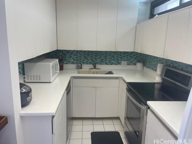 kitchen featuring appliances with stainless steel finishes, sink, decorative backsplash, and white cabinets