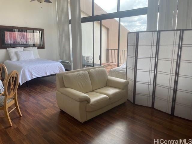 bedroom with floor to ceiling windows and dark hardwood / wood-style floors