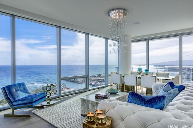 sunroom featuring a water view and a notable chandelier