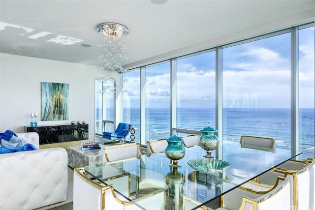 dining space featuring a water view and a notable chandelier