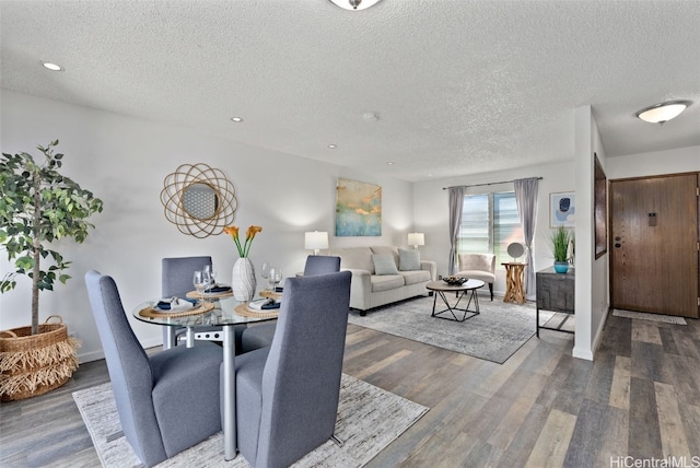 dining room with wood-type flooring and a textured ceiling