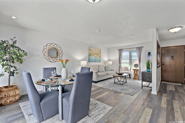 dining space with recessed lighting, a textured ceiling, baseboards, and wood finished floors