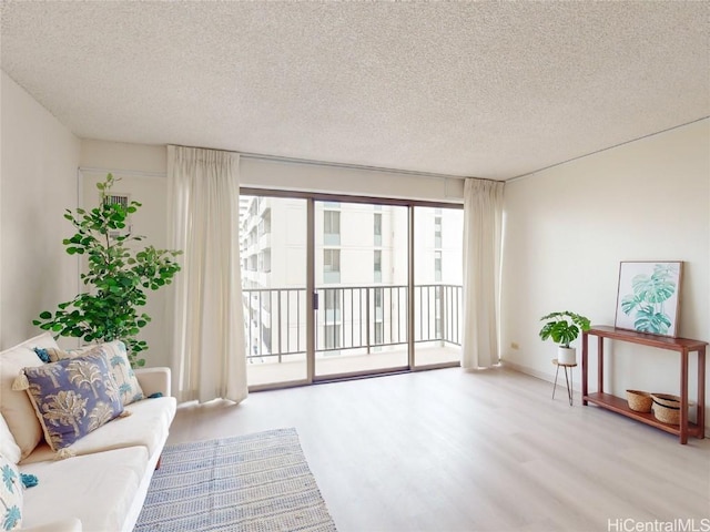 living room featuring light hardwood / wood-style flooring and a textured ceiling