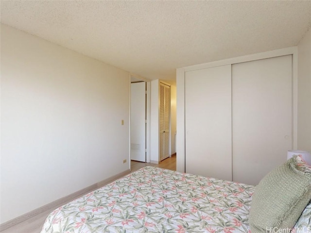 bedroom with two closets and a textured ceiling