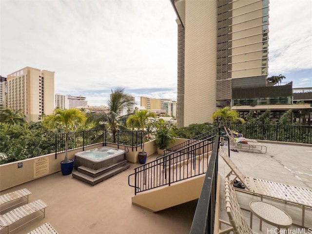 balcony with a hot tub and a patio