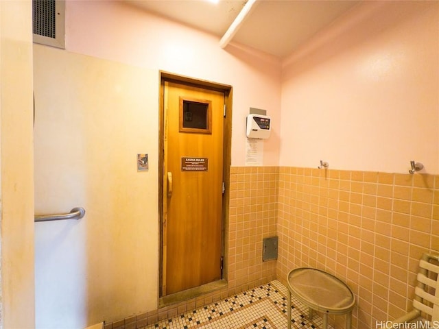 bathroom with tile patterned floors and tile walls