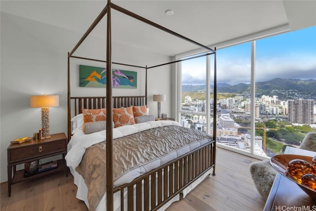 888 Kapiolani Blvd Unit Ph4501, Honolulu, HI 96813 - bedroom featuring a view of city, a mountain view, a wall of windows, and wood finished floors