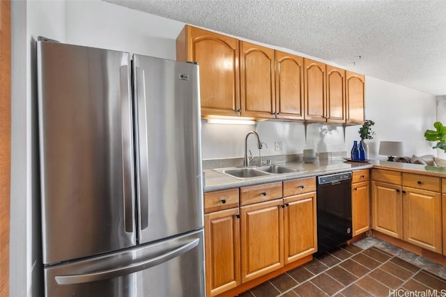 kitchen with sink, a textured ceiling, stainless steel refrigerator, and black dishwasher