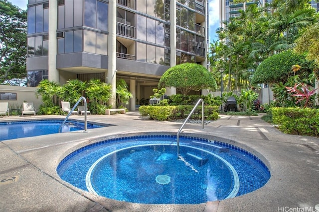 view of swimming pool with a hot tub