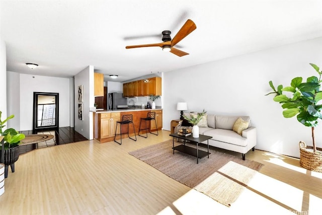 living room with ceiling fan and light hardwood / wood-style floors