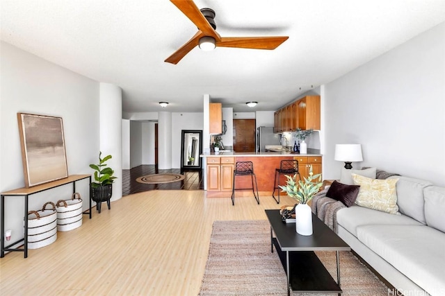 living room with ceiling fan and light wood-type flooring