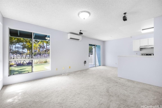 unfurnished living room featuring carpet floors, a wall mounted AC, and a textured ceiling