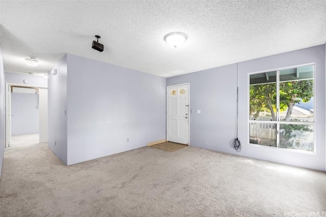 empty room featuring light carpet and a textured ceiling