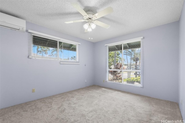 spare room featuring ceiling fan, a textured ceiling, carpet, and an AC wall unit