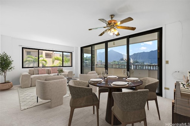 carpeted dining space with a mountain view and ceiling fan