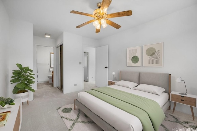 carpeted bedroom featuring ceiling fan and ensuite bath