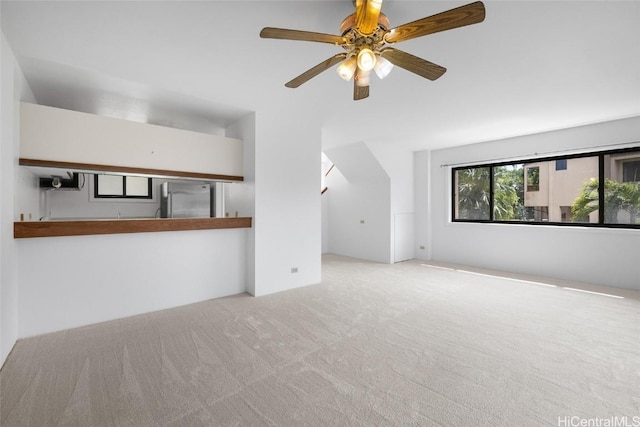 unfurnished living room featuring light carpet and ceiling fan