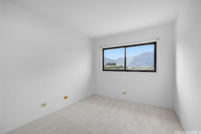 spare room with light carpet and a mountain view