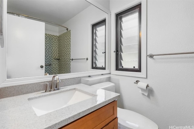 bathroom featuring vanity, toilet, and a shower