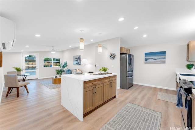 kitchen featuring stainless steel refrigerator with ice dispenser, a wall mounted AC, hanging light fixtures, a kitchen island, and light hardwood / wood-style floors