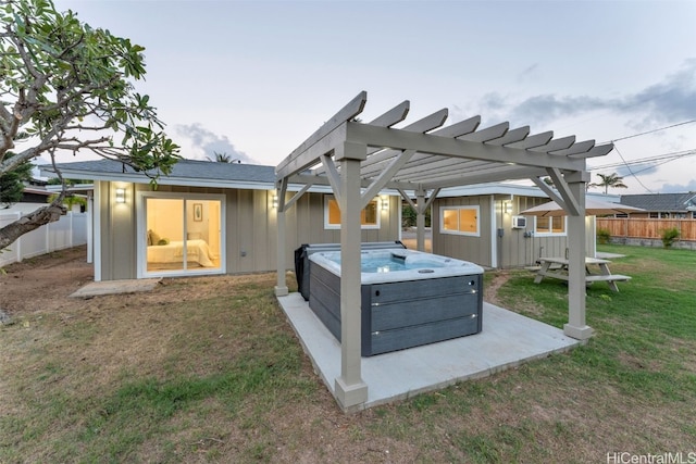 exterior space with an outbuilding, a hot tub, a pergola, and a lawn