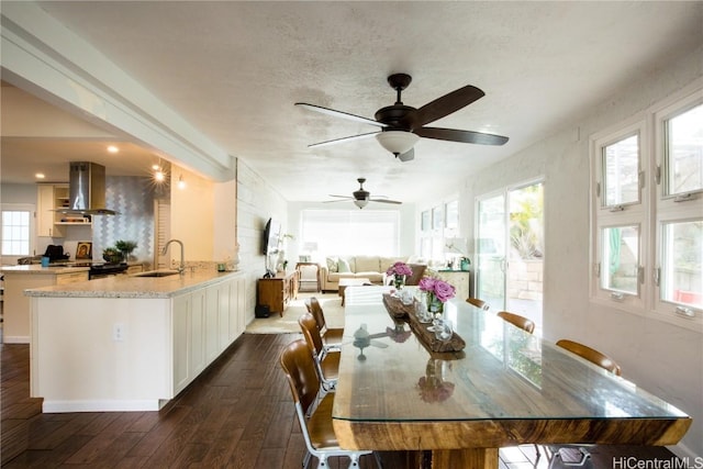 dining space with dark hardwood / wood-style flooring, sink, and a textured ceiling